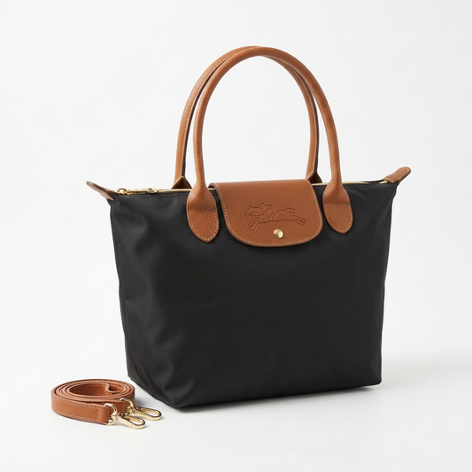 Black large bag with tan handles and strap neatly placed beside it on a white background